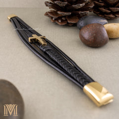 Flat lay of engraved gold clasp and cross bracelet