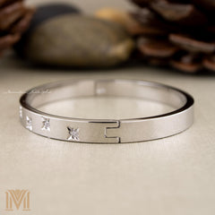 Silver bangle side view with star accents