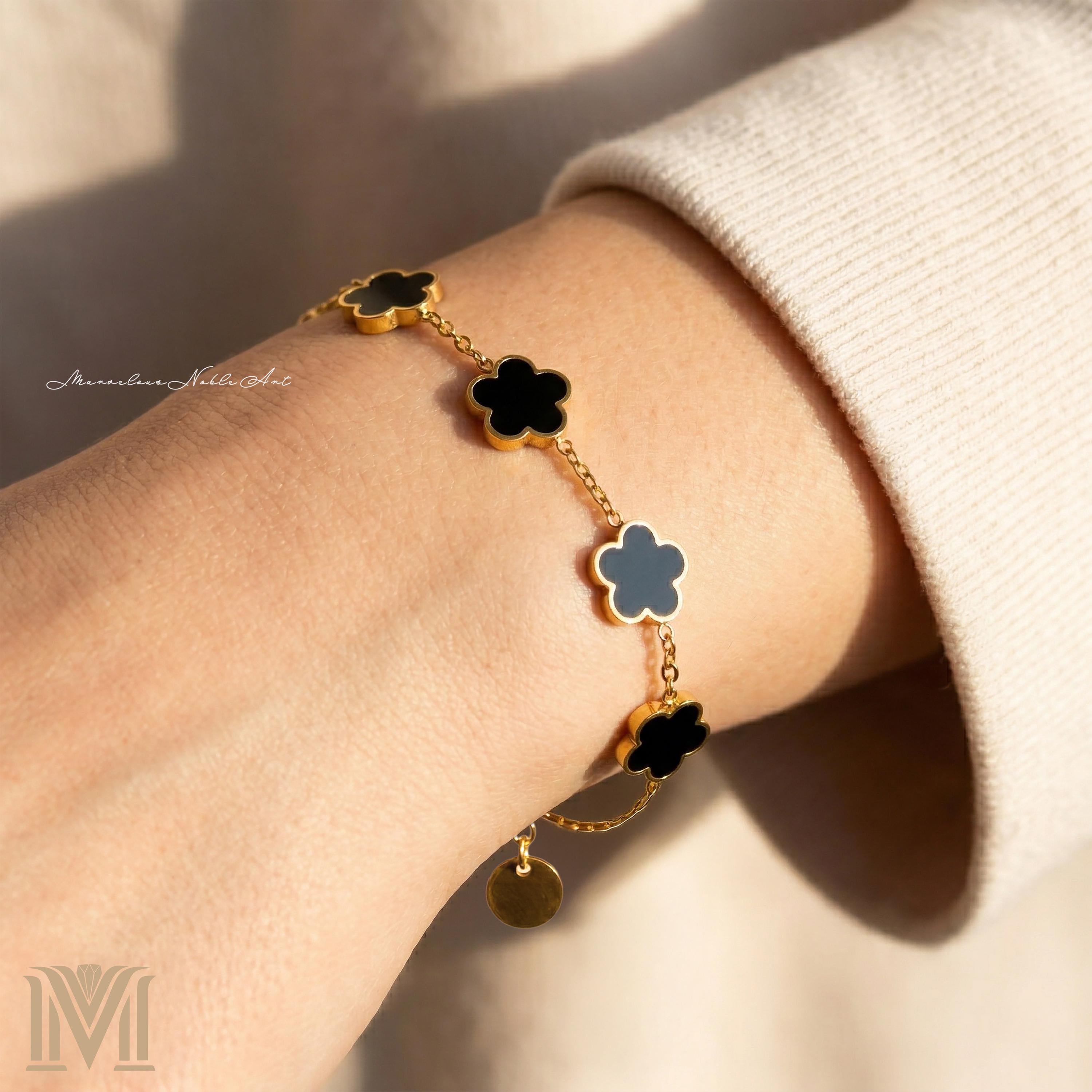 Gold and black clover bracelet worn on wrist