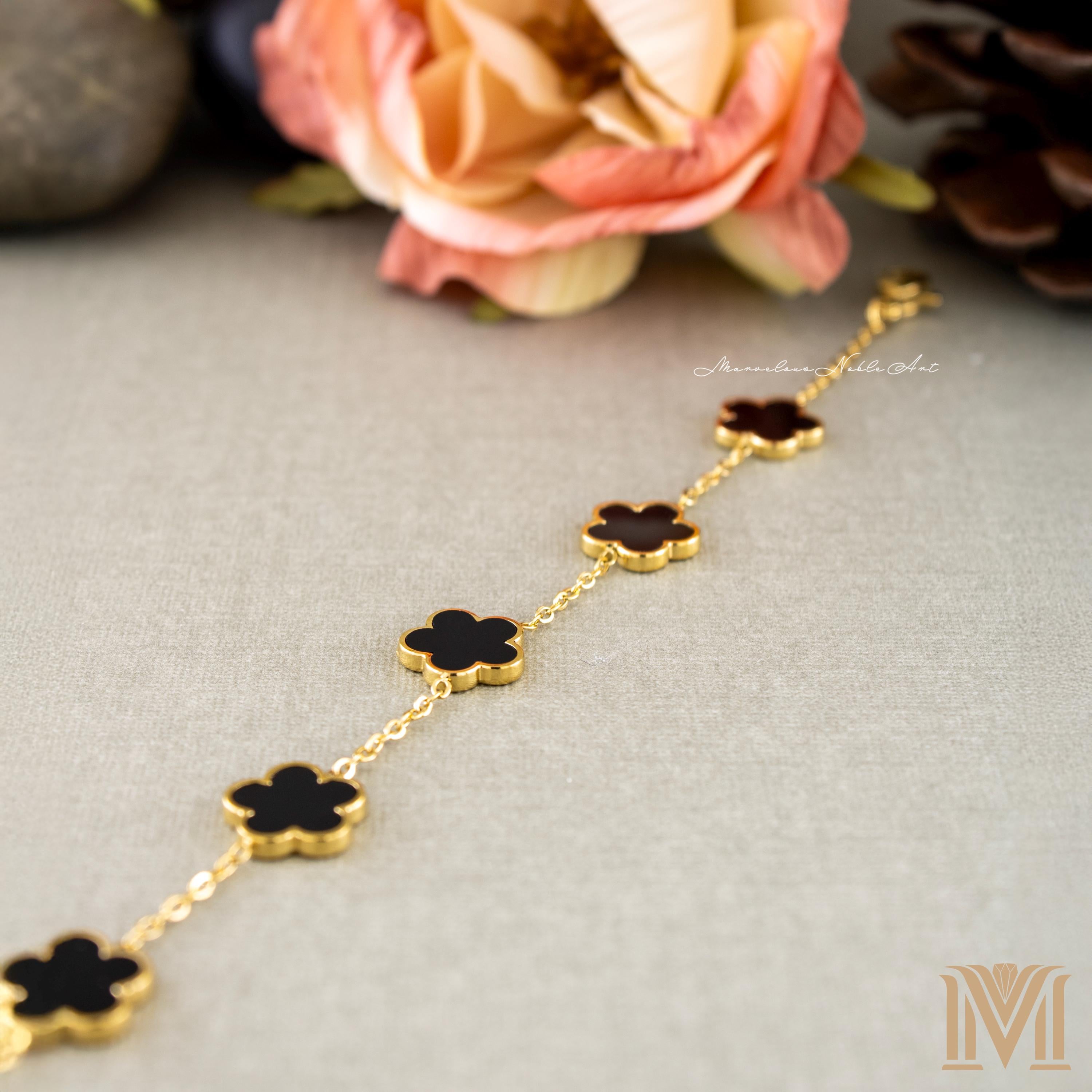 Gold and black clover bracelet flat lay