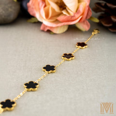Gold and black clover bracelet flat lay