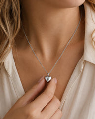 Woman wearing silver heart memorial urn necklace