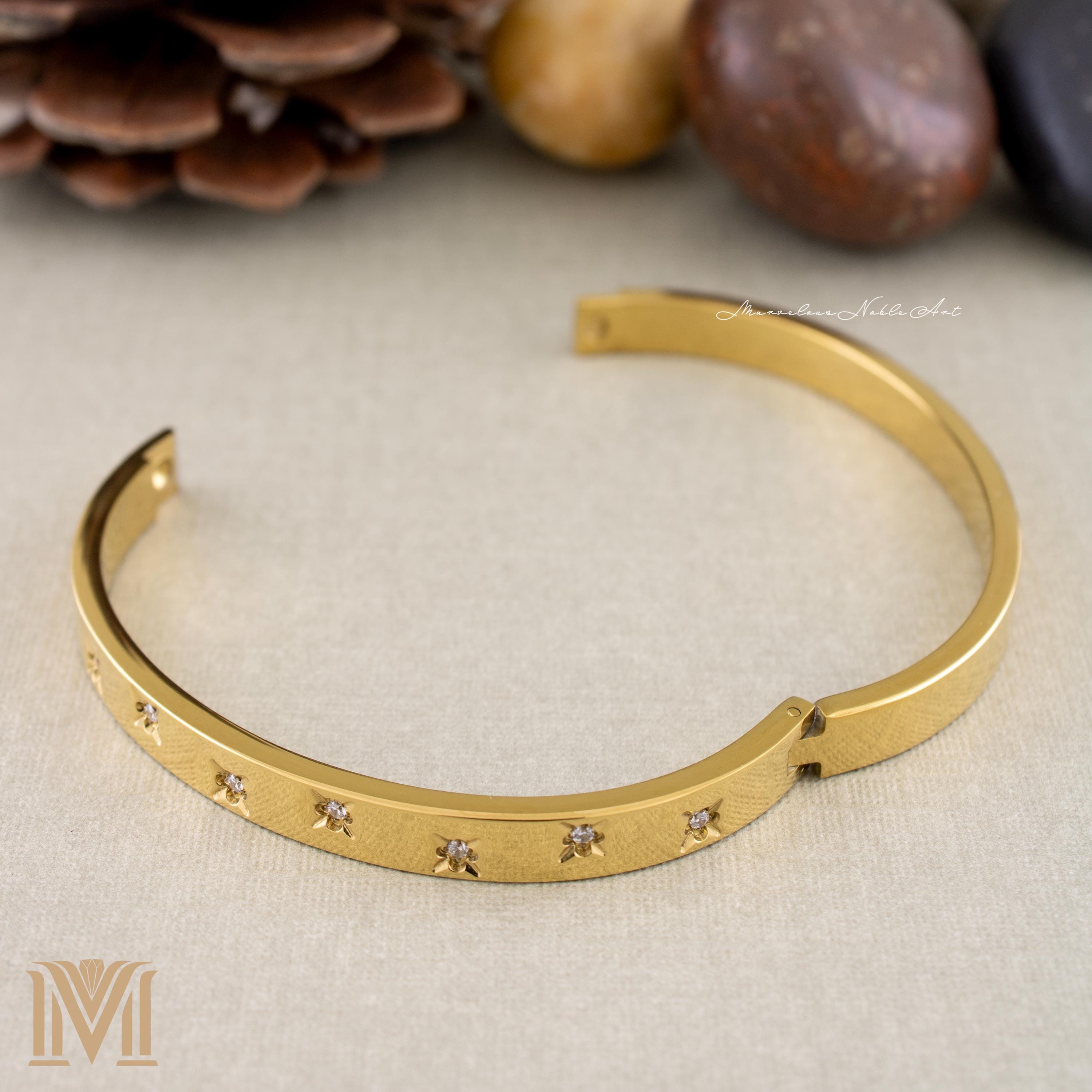 Open clasp detail of gold bangle