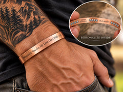 Tattooed man wearing personalized pure copper cuff with engraving inset